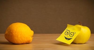 Apple with sticky post-it note looking at lemon