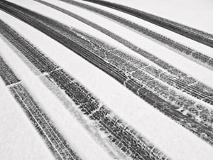 Winter at a glance, in black and white Recent tire tracks through snow on ramp to garage