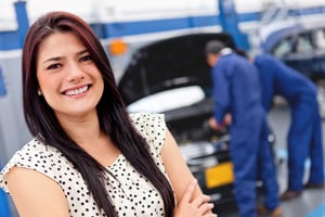 Woman at a car garage getting mechanical service